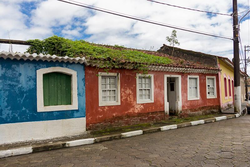 Rua de pedra do centro histórico de Cananéia com casarios coloridos